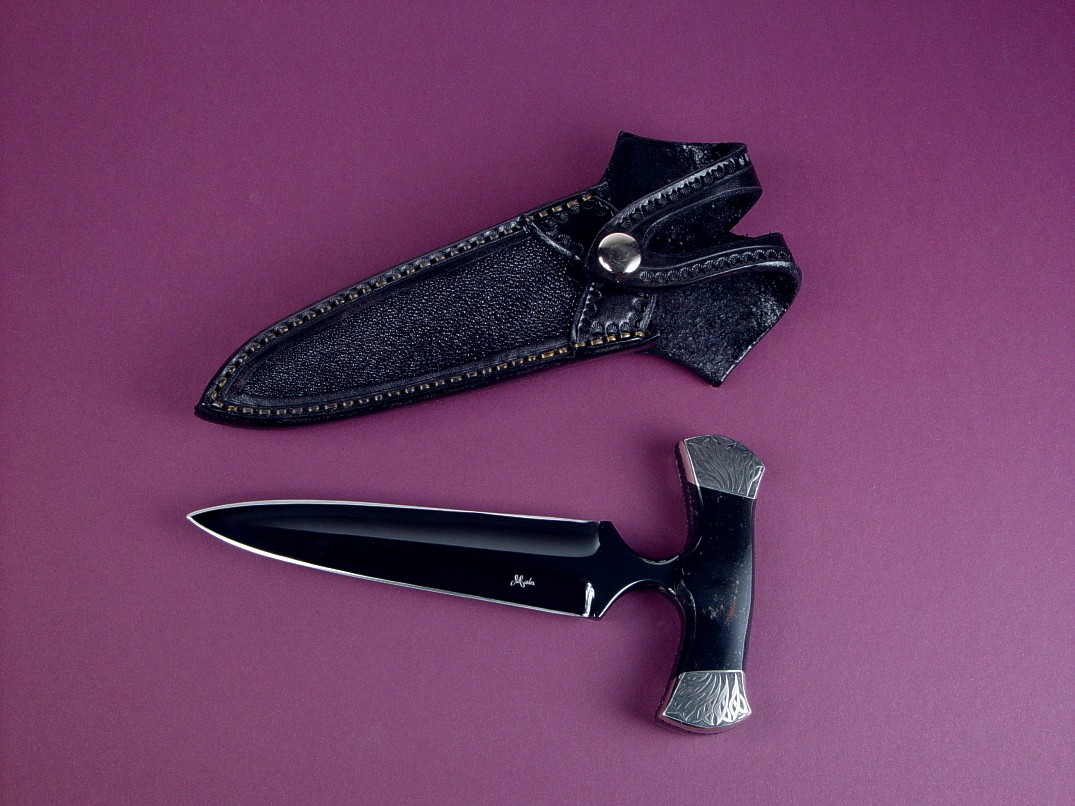 "Grim Reaper" push dagger, obverse side view in blued O1 high carbon tungsten-vanadium tool steel blade, hand-engraved nickel silver bolsters, Australian Black Jade gemstone handle, stingray inlaid in hand-carved leather sheath, kydex, aluminum, nickel plated steel sheath