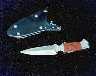 The "Kid" CSAR double edged knife with hookblade, obverse side view in 440C high chromium stianless steel blade, hand-engraved 304 stainless steel bolsters, brecciated jasper gemstone handle, locking kydex, aluminum, stainless steel sheath