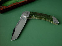 "Procyon" liner lock folding knife, obverse side view, in hand-engraved ATS-34 high molybdenum stainless steel blade, hand-engraved 304 stainless steel bolsters, anodized 6AL4V titanium liners and lockplate, Pounamu New Zealand Greenstone Nephrite Jade gemstone handle, case of Granite, Quartz Terrazzo composite